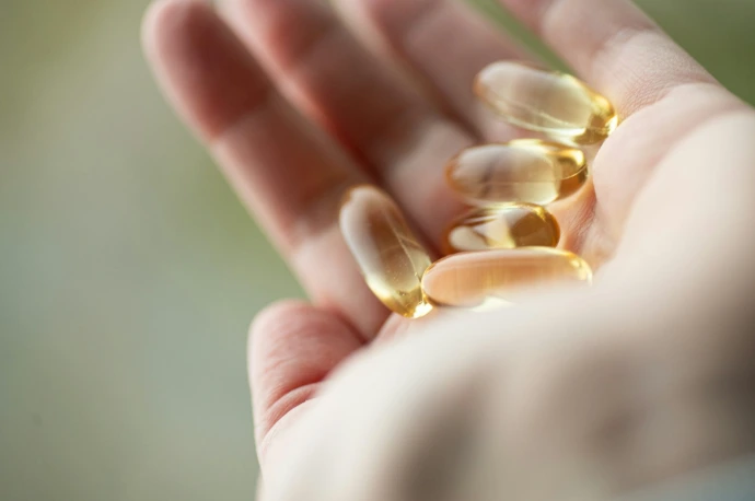 A person holding a handful of pills in their hand